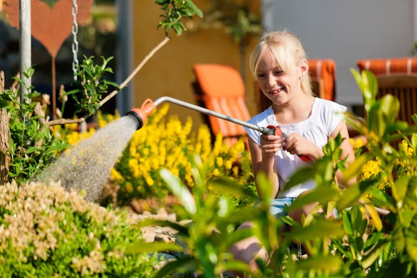 Gelukkig kind drenken bloemen — Stockfoto