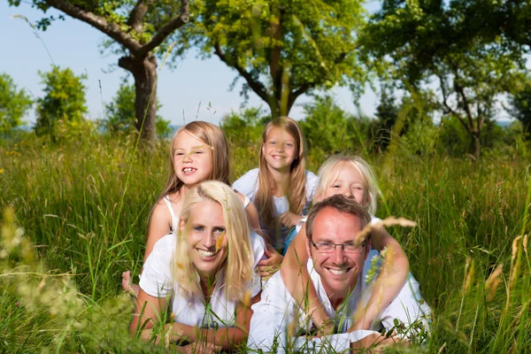 Familie liggen in de weide — Stockfoto