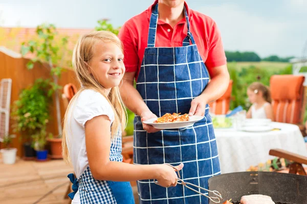 Familia feliz teniendo una barbacoa — Foto de Stock