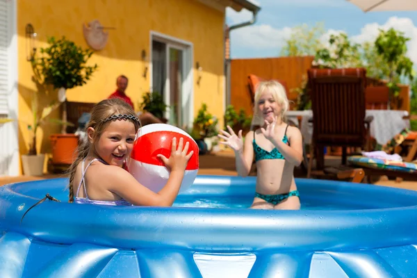 Crianças brincando com bola na piscina de água — Fotografia de Stock