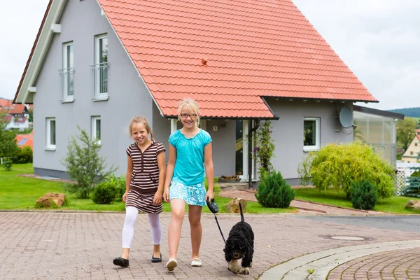 Duas meninas ou crianças andando com o cão — Fotografia de Stock