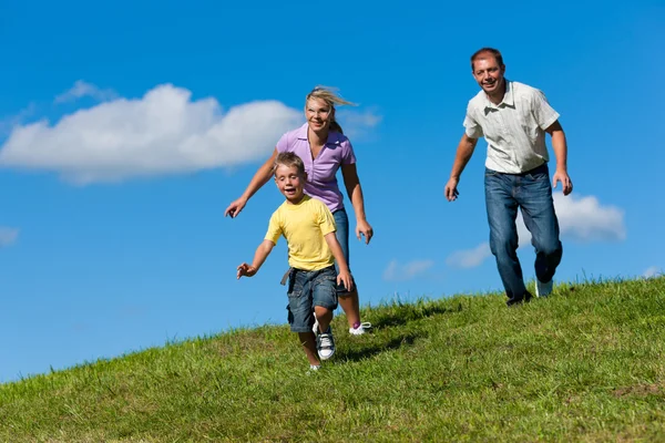 Family outdoors is running on a meadow Stock Photo