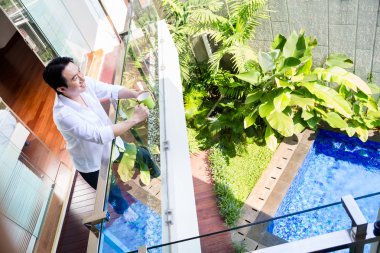 Balkonda kahve ile ev Çinli adam