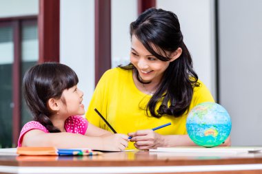 Çin anne çocuk ile okulun ödevlerini yapıyor