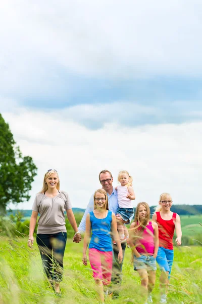 Wandelen in de weide en gelukkige familie — Stockfoto
