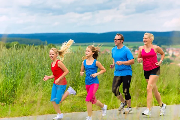 Happy Family está corriendo al aire libre en verano —  Fotos de Stock