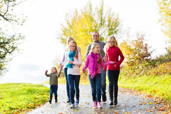 Family taking walk in autumn forest — Stock Photo, Image