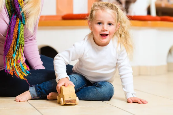 Meisje spelen houten speelgoedauto — Stockfoto