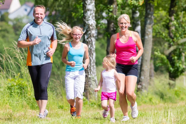 Familiesport joggen door veld — Stockfoto