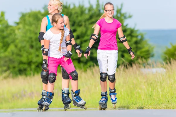 Rollerblade família com patins na faixa de país — Fotografia de Stock