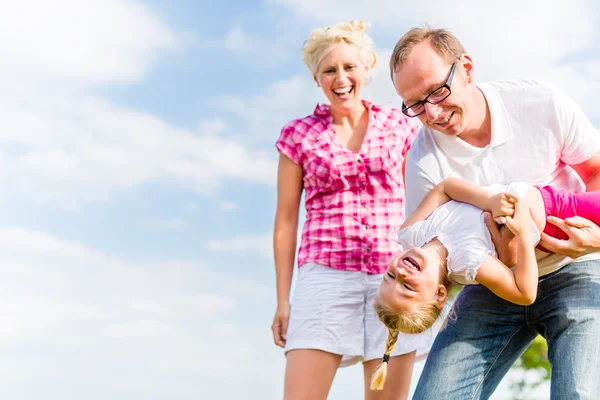 Familie tobt auf Feld — Stockfoto