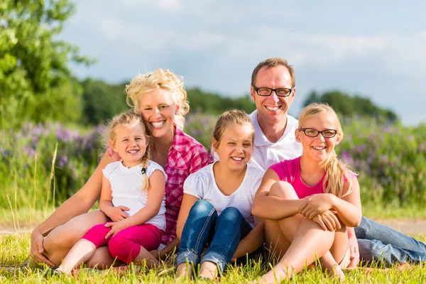 Familie sitzt auf Gras im Rasen oder Feld — Stockfoto