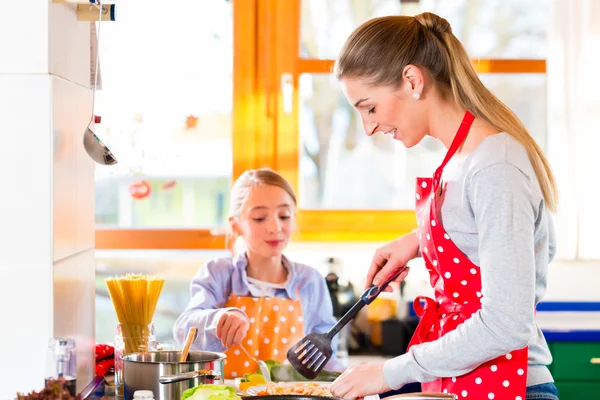 Madre enseñando a hija a cocinar en casa — Foto de Stock