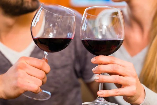 Jeune beau couple buvant du vin rouge à la maison — Photo