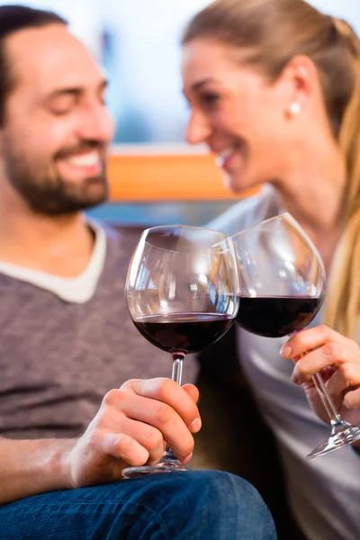 Bonito casal beber vinho tinto em casa — Fotografia de Stock