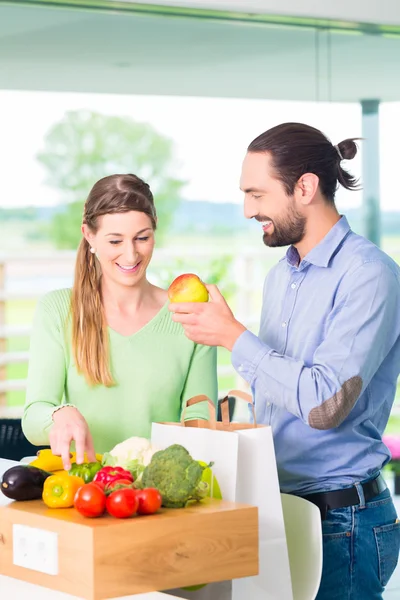 Couple unpacking grocery shopping bag at home — Stock Photo, Image