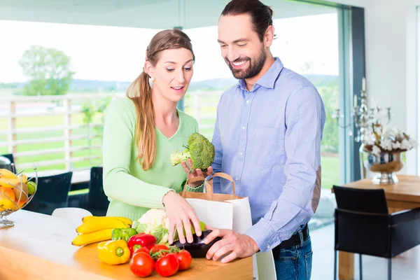 Couple unpacking grocery shopping bag at home — Stock Photo, Image