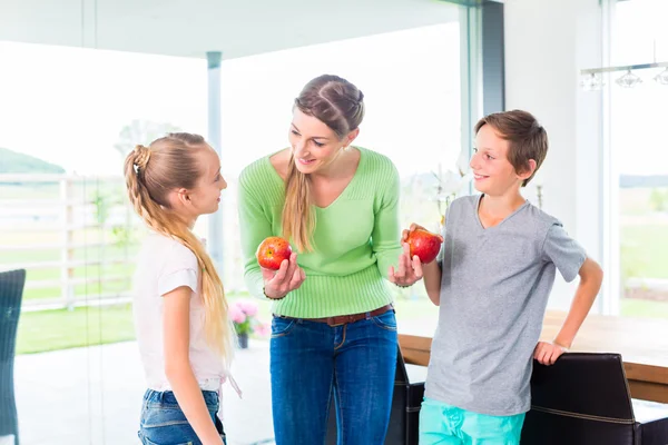 Madre dando a los niños manzana para una vida saludable — Foto de Stock