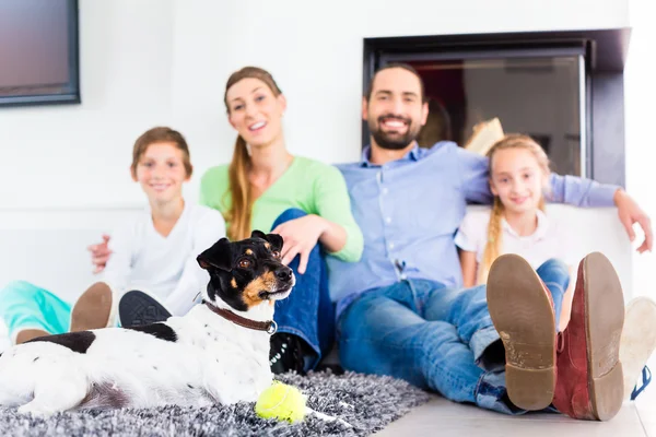 Familjen sitter med hund på vardagsrum — Stockfoto