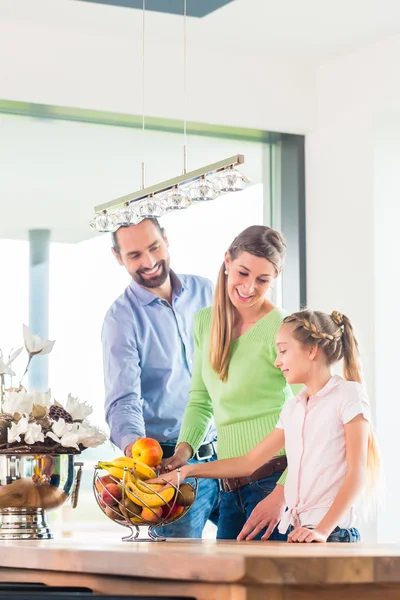 Família comer frutas frescas na cozinha — Fotografia de Stock