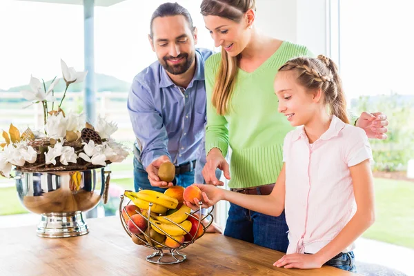 Família comer frutas frescas na cozinha — Fotografia de Stock