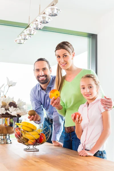 Familia comiendo frutas frescas en la cocina — Foto de Stock