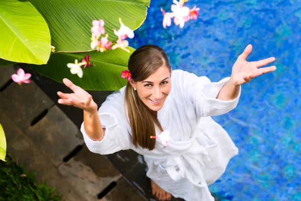 Donna con fiori a bordo piscina tropicale — Foto Stock