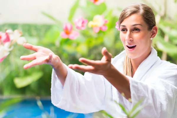 Mulher com flores à beira da piscina tropical — Fotografia de Stock