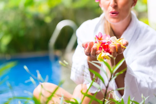 Donna con fiori alla piscina tropicale — Foto Stock