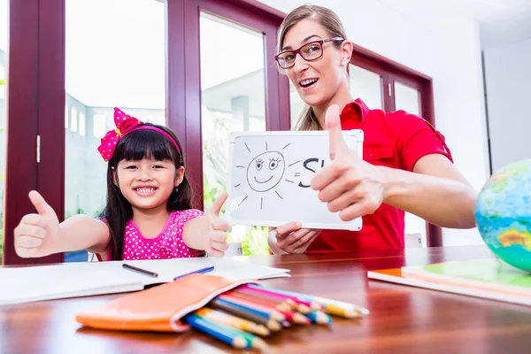 Teacher giving language lessons to Chinese child