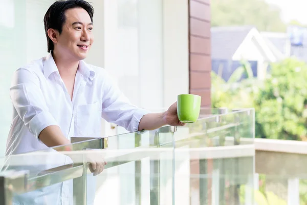 Hombre chino en el balcón de casa con café —  Fotos de Stock