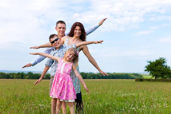 Happy family on a meadow in summer — Stock Photo, Image