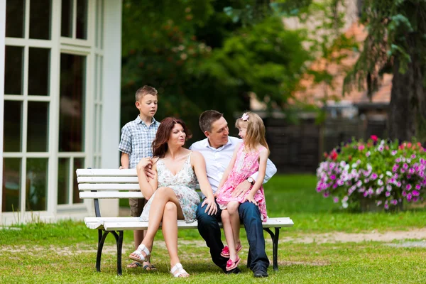Familjen sitter framför sitt hem — Stockfoto