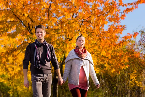 Paar spaziert im Herbst vor bunten Bäumen — Stockfoto