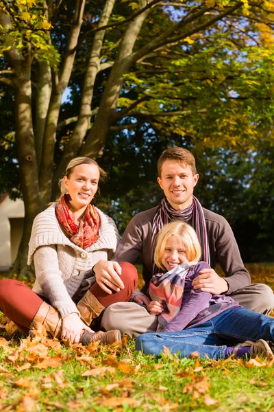 屋外秋の草の上に座って幸せな家族 — ストック写真