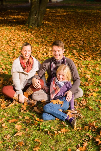 Familia feliz al aire libre sentado en la hierba en otoño —  Fotos de Stock