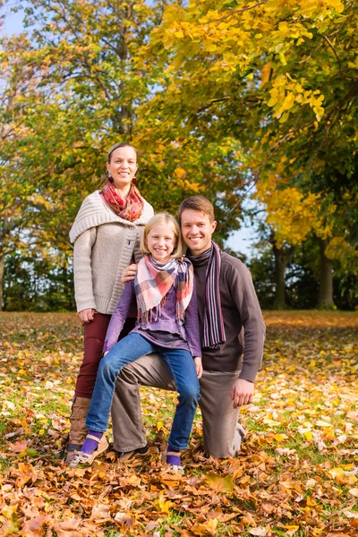 Οικογένεια μπροστά από πολύχρωμα δέντρα το φθινόπωρο ή πτώση — Φωτογραφία Αρχείου
