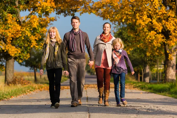 Familj med promenad framför färgglada träd i höst — Stockfoto