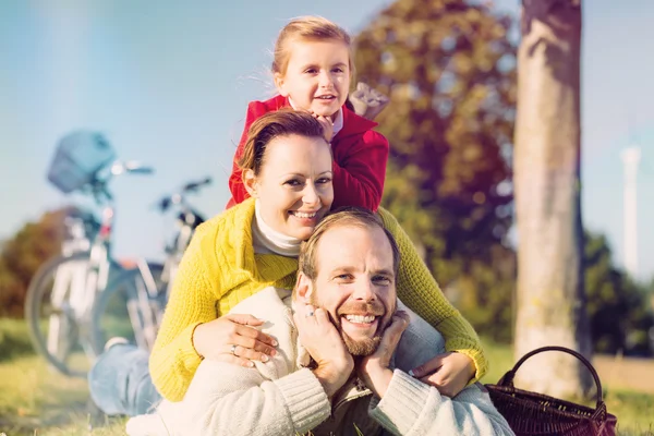Família com bicicleta no parque no outono — Fotografia de Stock