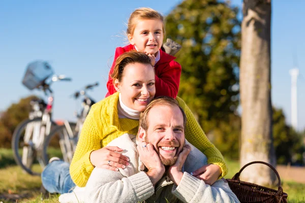 Família com bicicleta no parque no outono — Fotografia de Stock