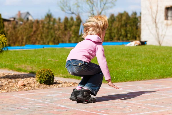 Flicka som leker i vårträdgård har roligt — Stockfoto