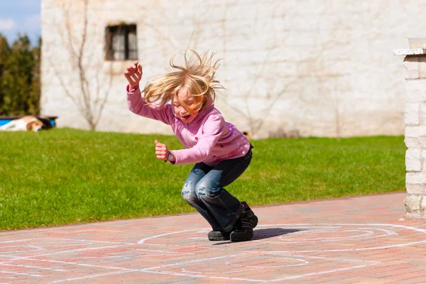 Meisje in lentetuin plezier spelen — Stockfoto