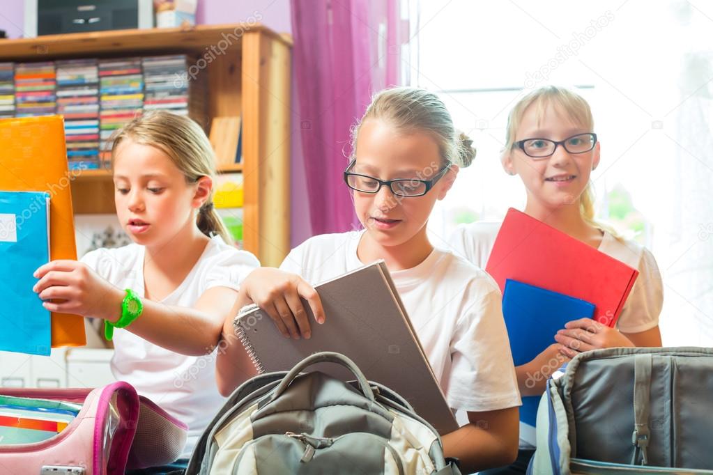 Girl packing school books in bag Stock Photos and Images