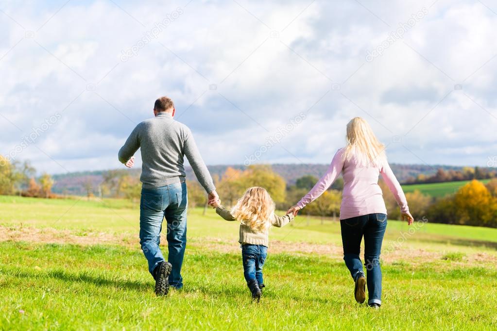 Family walk through the park in fall or autumn