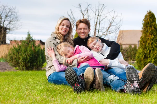 Familie sitzt im Frühling zusammen auf einer Wiese — Stockfoto