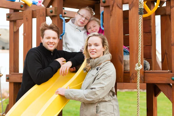 Família no parque infantil — Fotografia de Stock