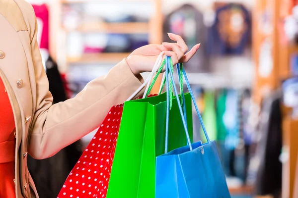 Vrouw met boodschappentassen in winkel — Stockfoto