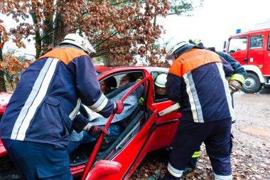 Accident - Fire brigade rescues Victim of a car clipart