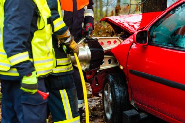 Fire brigade rescues Victim of a car clipart