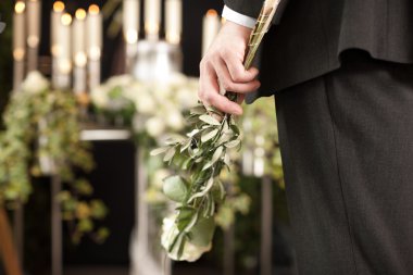 Grief - man with white roses at urn funeral clipart